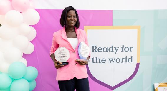 Portia Dzifa Dzilah smiling at camera holding awards